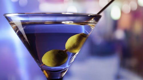 A martini in a glass with two olives