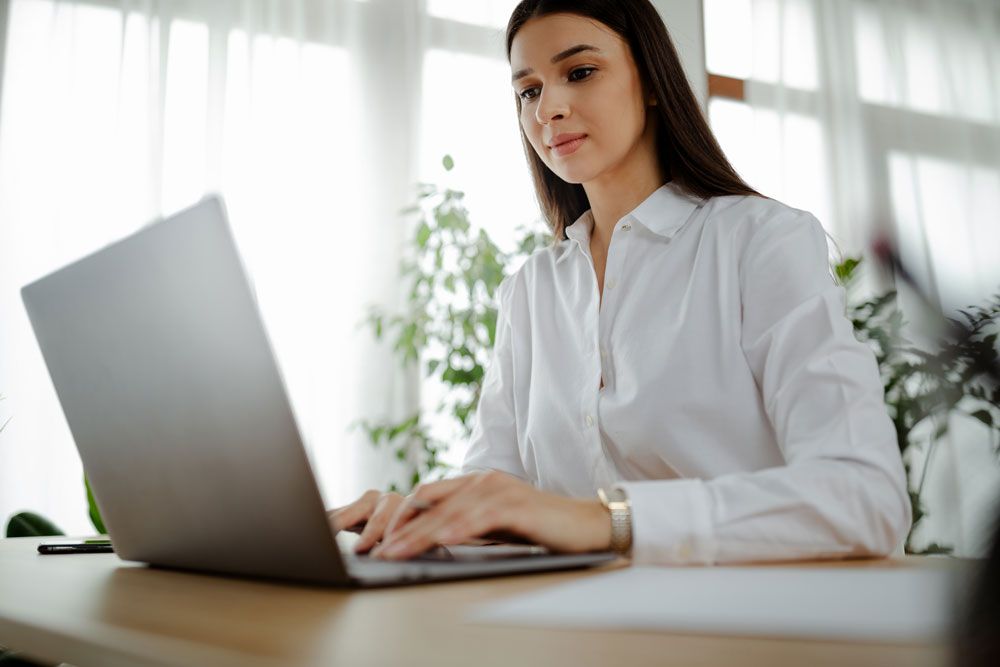 Young woman in yellow top using online assessment software